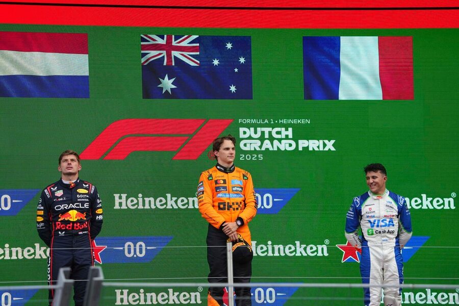 Oscar Piastri, Max Verstappen a Isack Hadjar na pódiu po VC Nizozemska