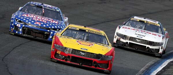 Joey Logano při závodu NASCAR, následován Rickym Stenhousem Jr. (vlevo) a Ryanem Blaineym