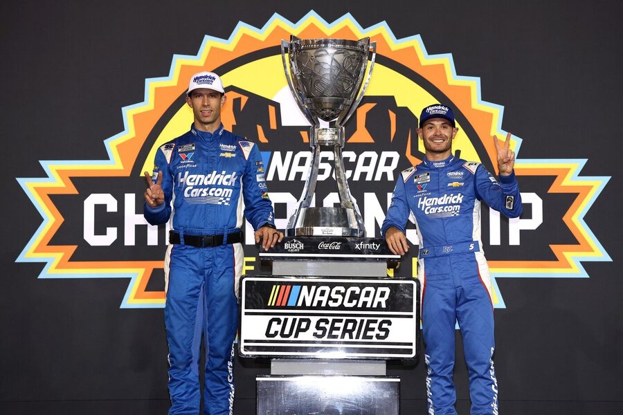 Šampion NASCAR Cup Series 2025 Kyle Larson (vpravo) s týmovým šéfem Cliffem Danielsem a s trofejí