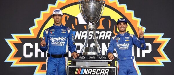 Šampion NASCAR Cup Series 2025 Kyle Larson (vpravo) s týmovým šéfem Cliffem Danielsem a s trofejí